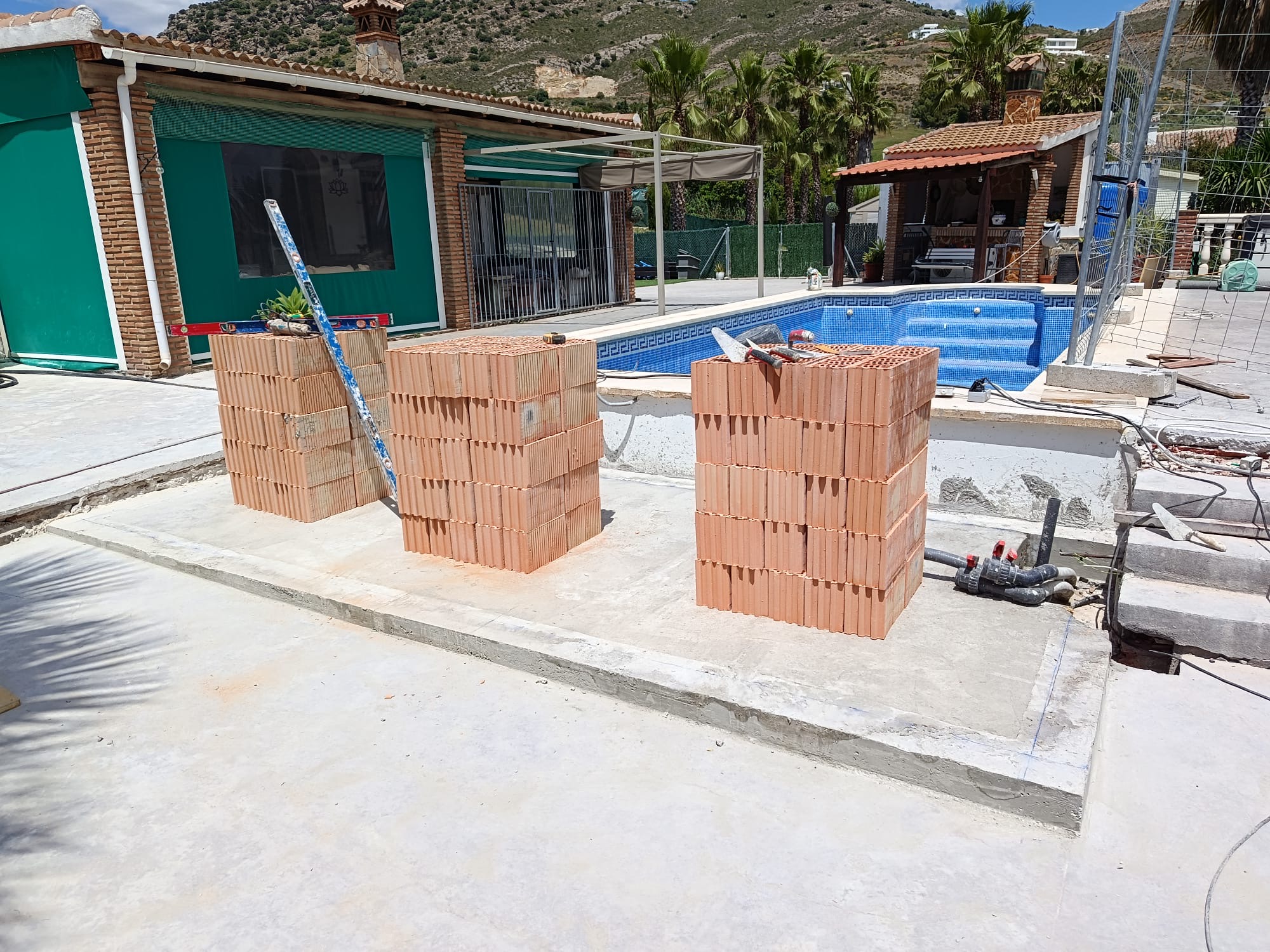 Masonry materials prepared at a real Mag Construction worksite beside a pool