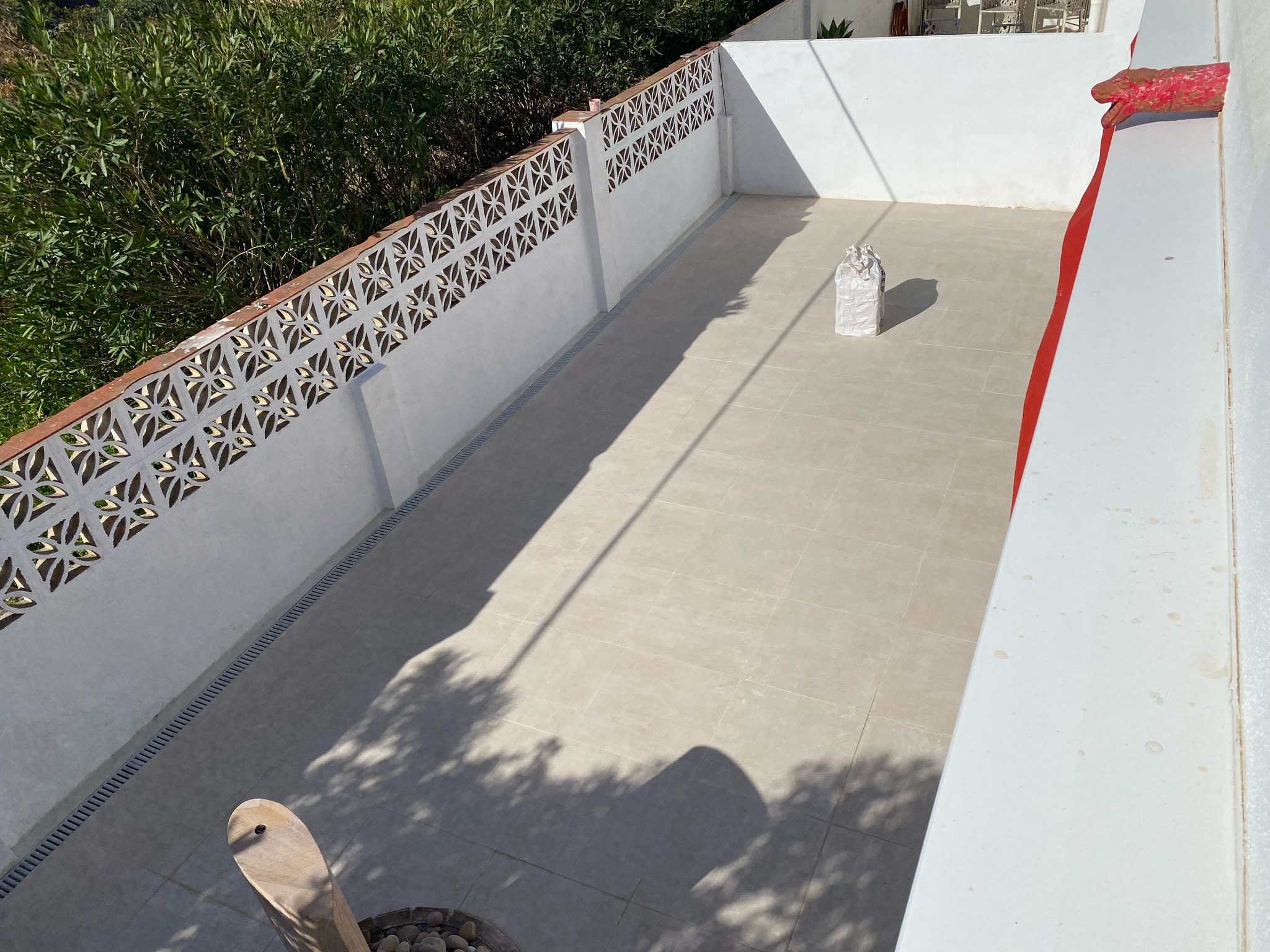 Completed pale tiled outdoor terrace with drainage channel