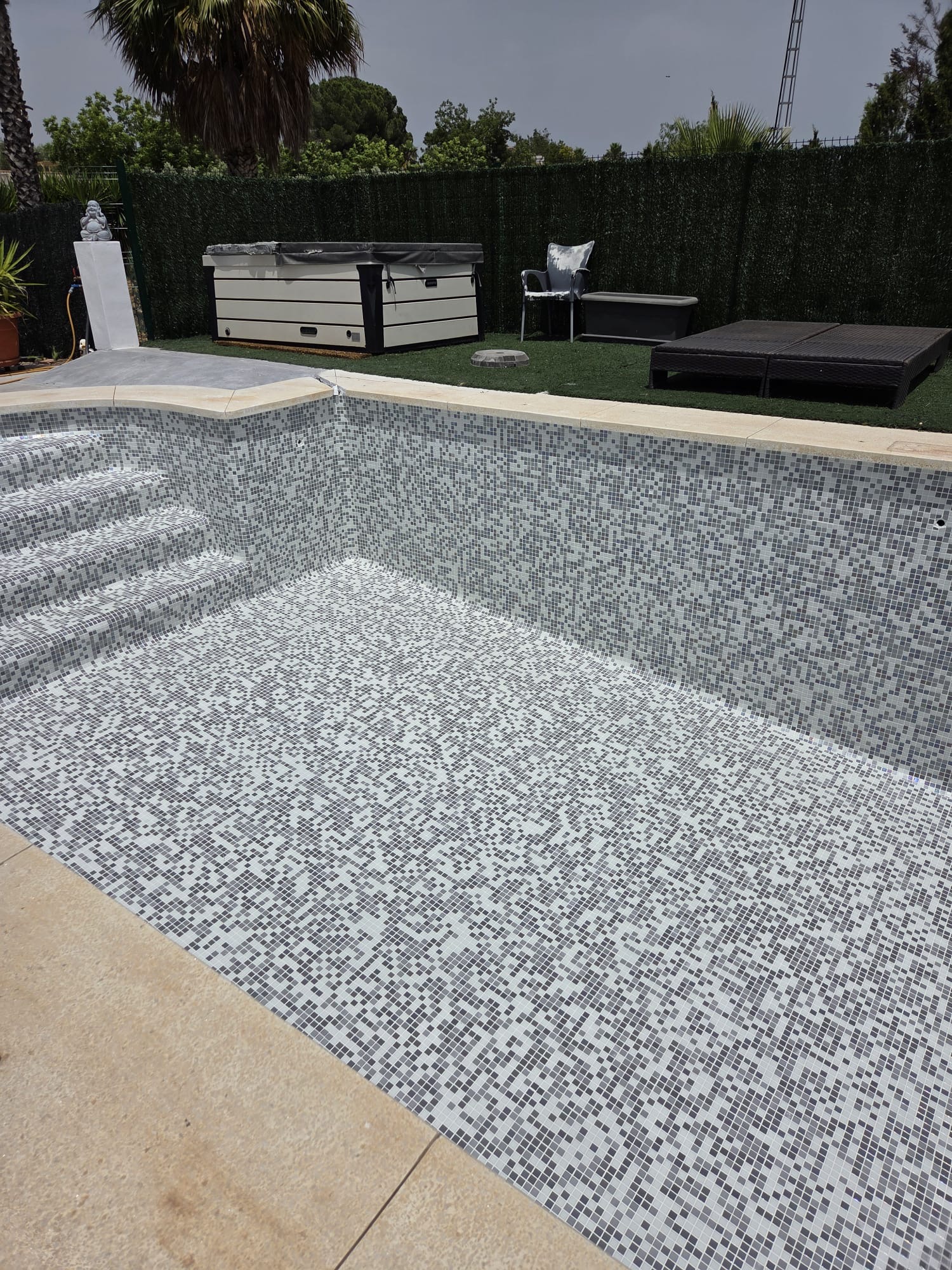 Swimming pool lined with grey and white mosaic tiles